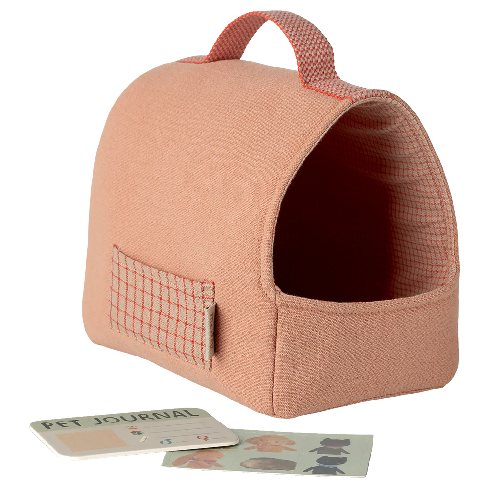 Coral pet carrier with a pet journal and cards on a white background
