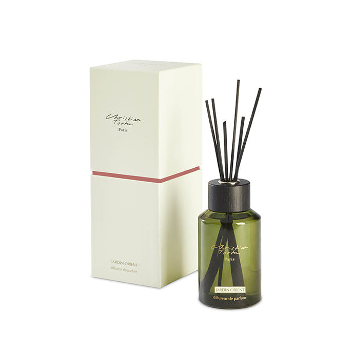 A Christian Tortu 250mL fragrance diffuser with green reeds and a beige bottle, placed next to its white packaging box.