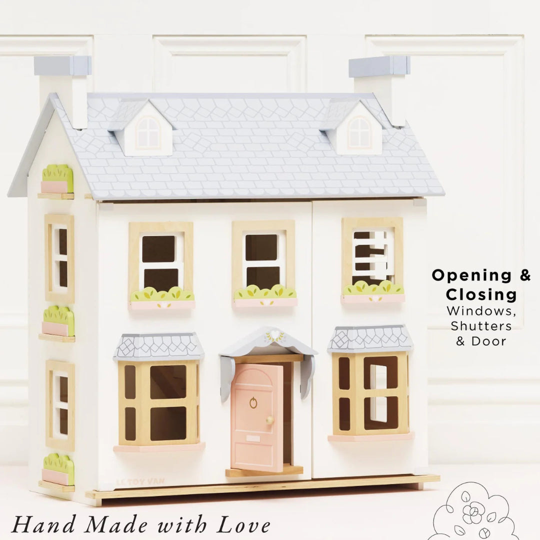 Toy dollhouse with opening windows, shutters, and door on a white background