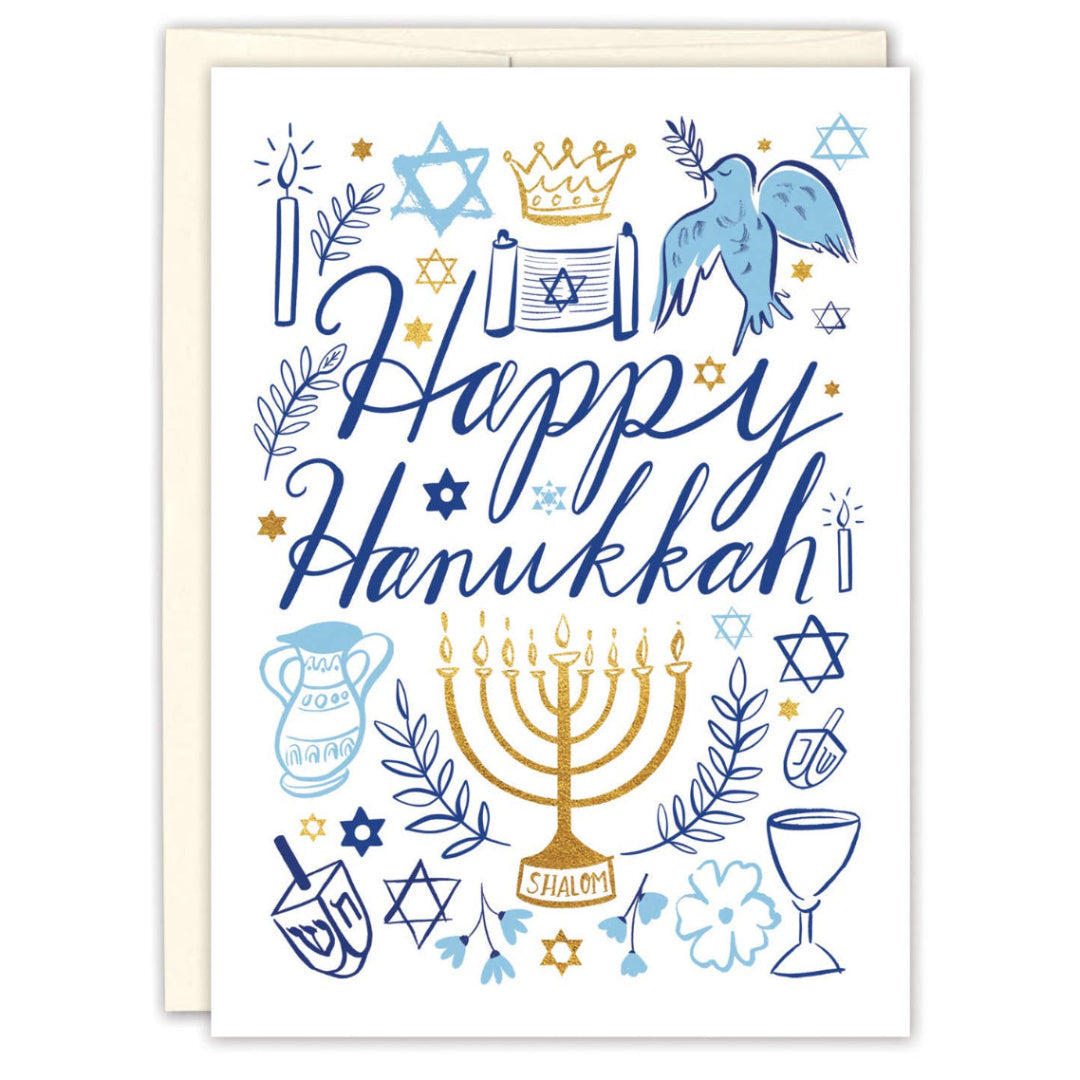 A Hanukkah greeting card with a white background, featuring blue and gold illustrations of a menorah, Star of David, dreidel, candles, dove, crown and lettering that reads 'Happy Hanukkah.' A light beige envelope is partially visible behind the card.