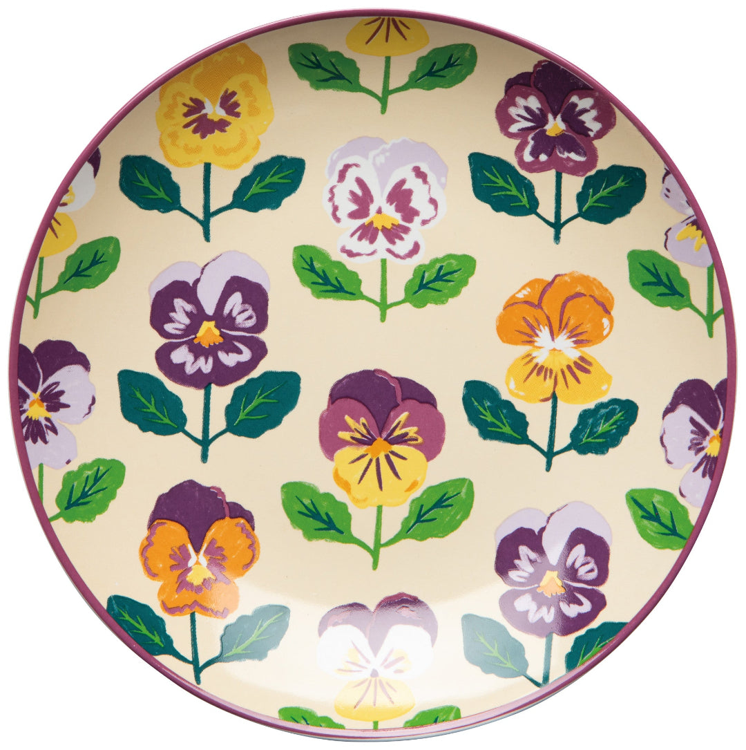 Round plate with colorful pansy flower pattern on a beige background