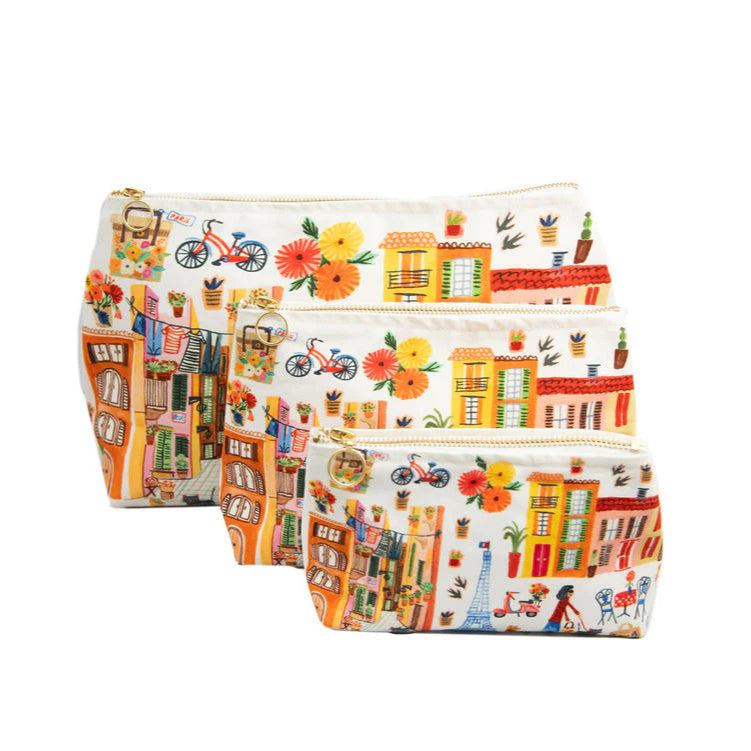 A set of three cosmetic bags with a printed design featuring houses, trees, and bicycles, in varying sizes.