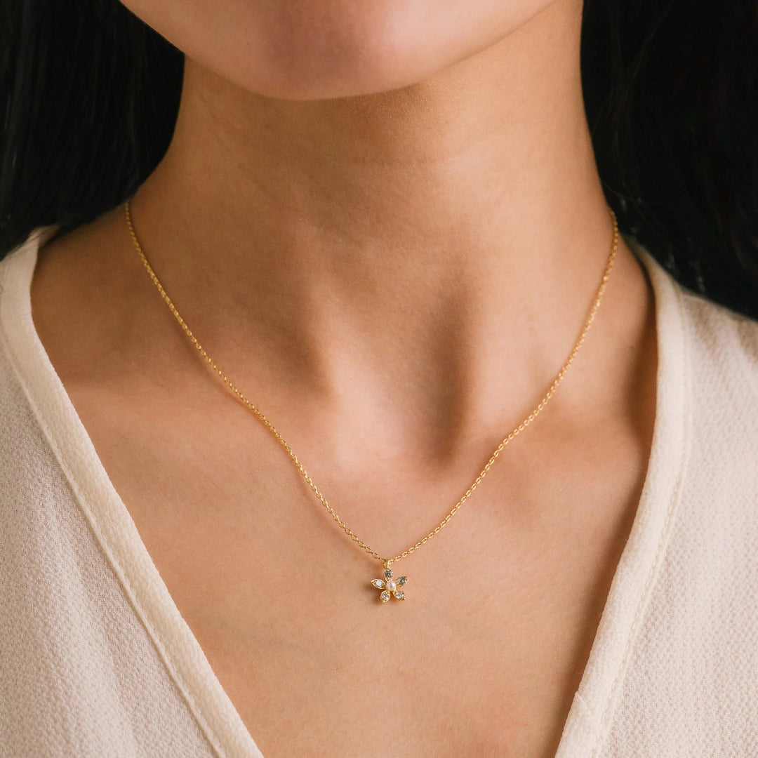 Gold necklace with a delicate pendant worn by a person