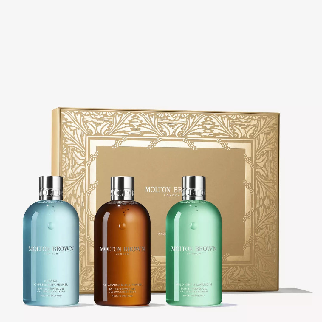Three Molton Brown bottles in front of a decorative box on a white background