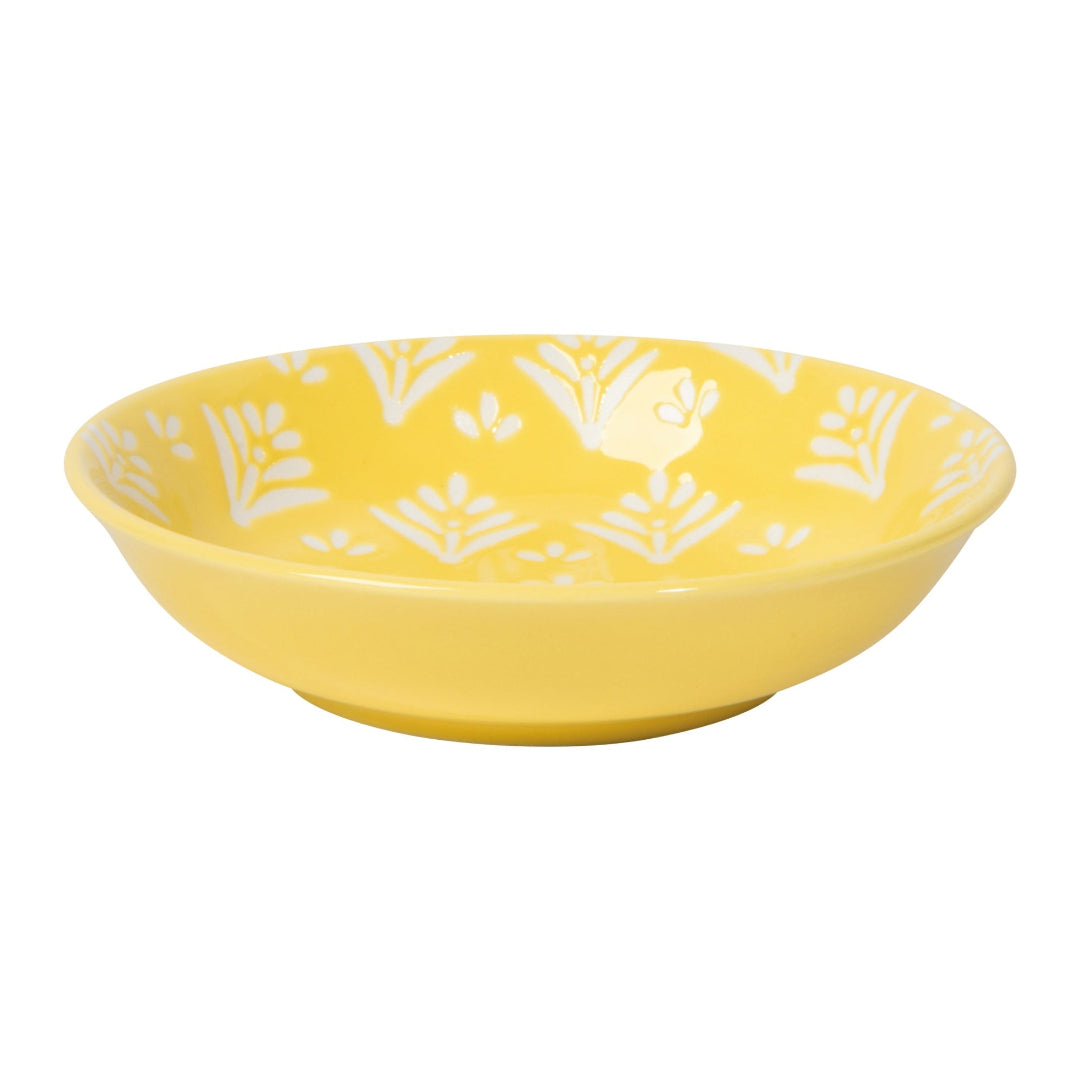 Yellow bowl with white floral patterns on a white background