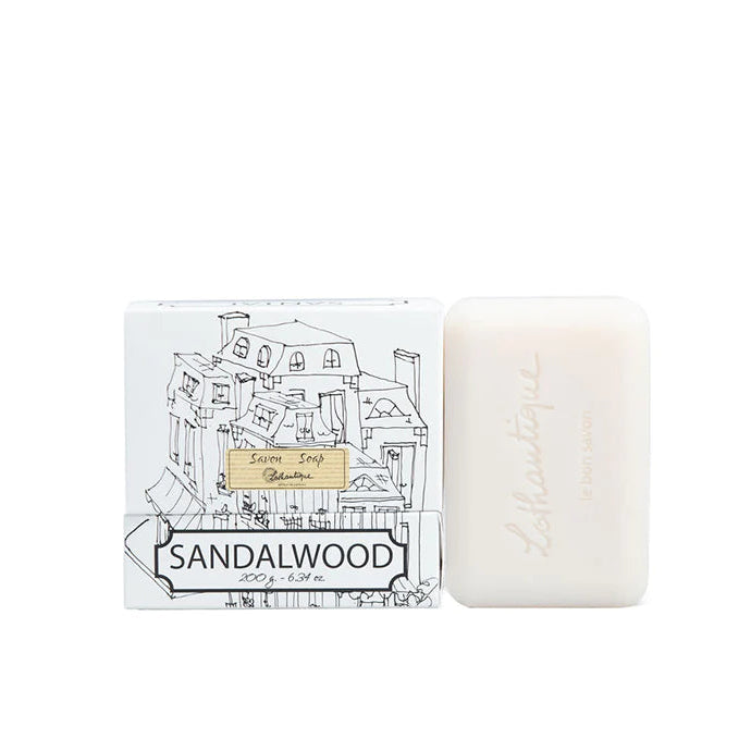 A bar of soap with a sandalwood fragrance, accompanied by its packaging which features a black and white illustration of a town square.