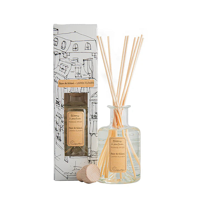 A Linden Flower fragrance diffuser set by Lothantique, including a clear bottle with reeds, a matching box, and a cork stopper.