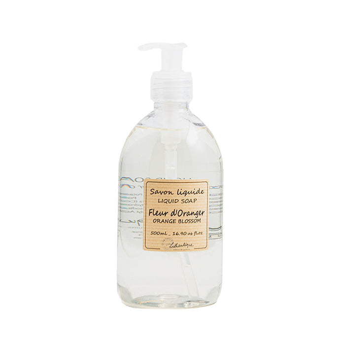 A clear plastic bottle with a pump dispenser containing Authentique Orange Blossom liquid soap.