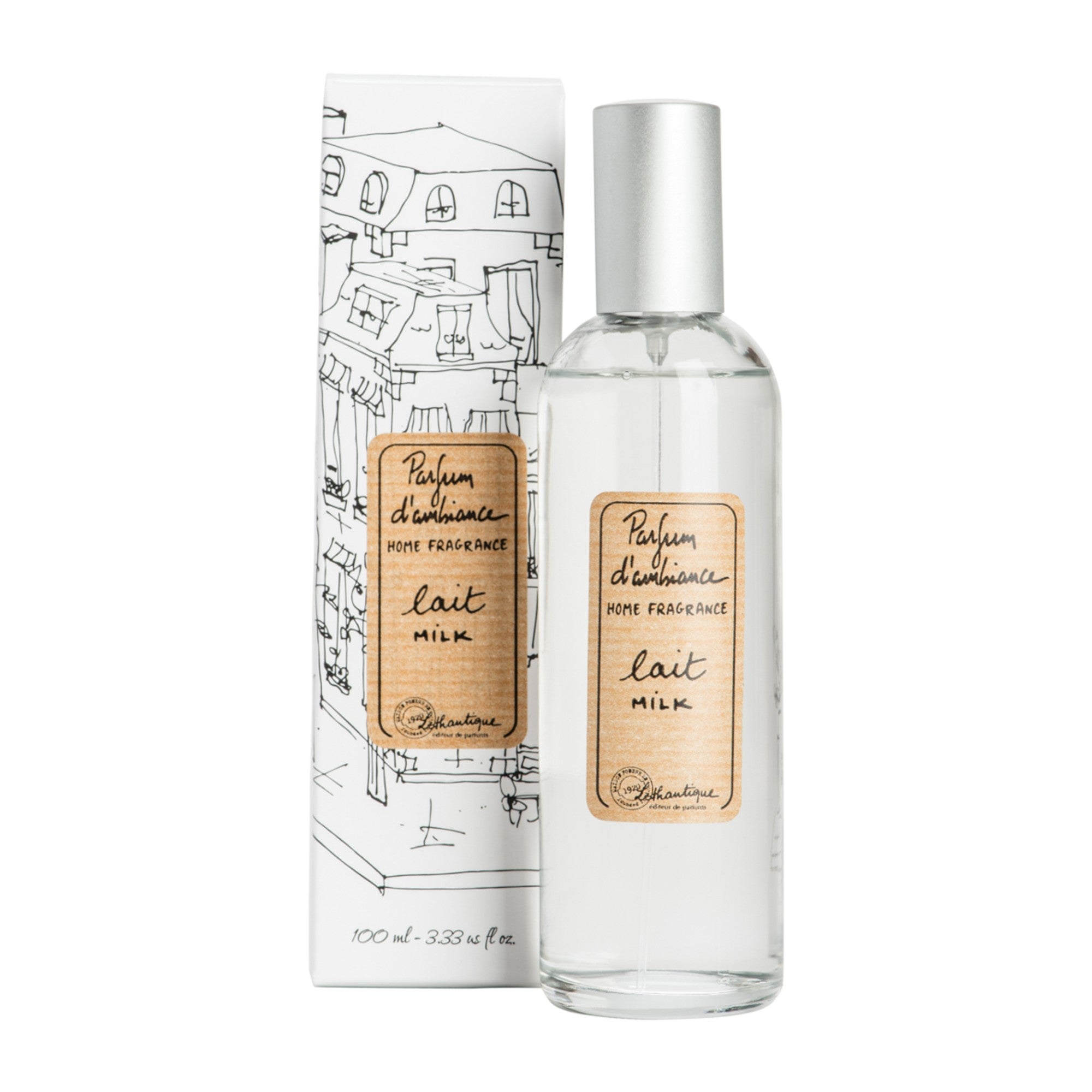 A clear glass room spray bottle with a label next to its packaging featuring a drawing of a house.