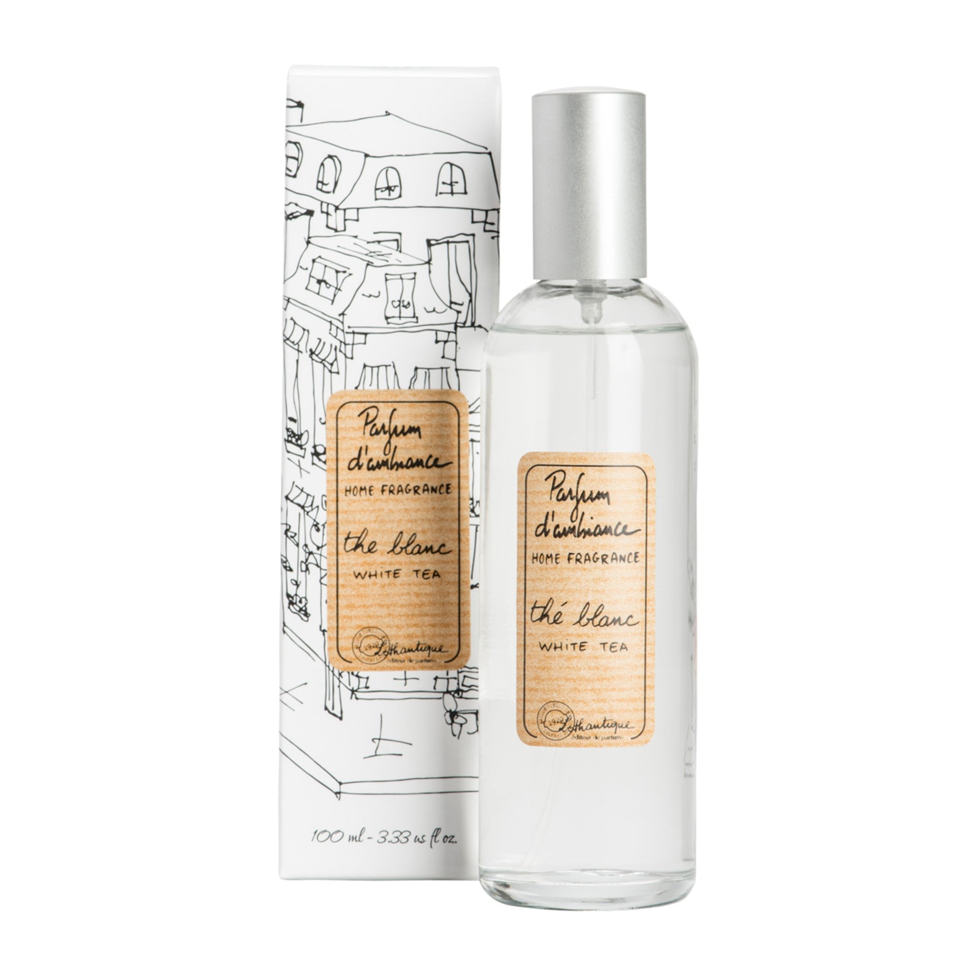 A clear glass room spray bottle with a label next to its packaging featuring a drawing of a house.