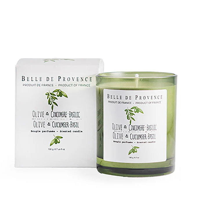 A green scented candle with a label reading 'OLIVE & CUCUMBER BASIL', alongside its white packaging box with the same product name and an image of olive leaves. Both the candle and the box carry the 'Belle de Provence' branding.