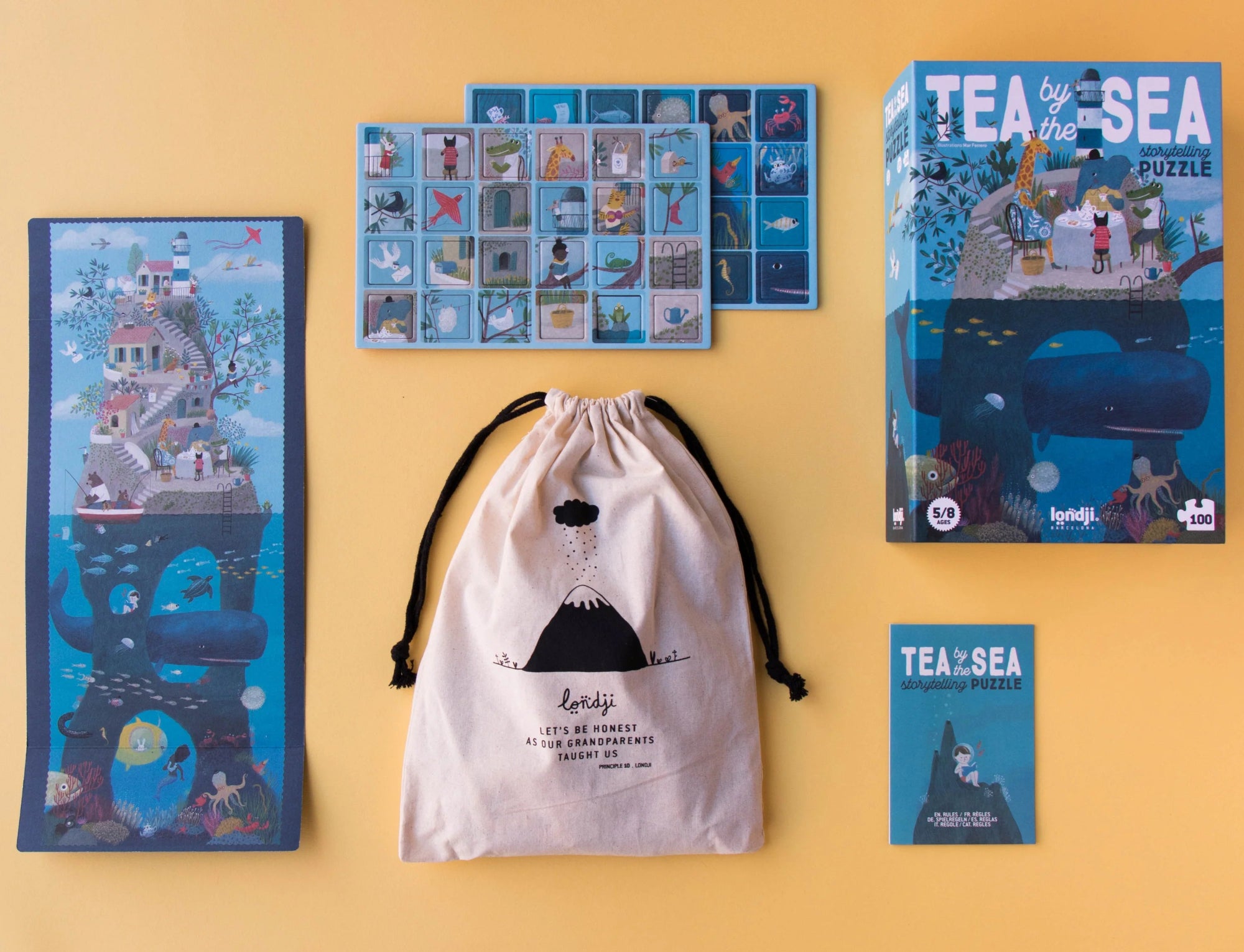 Tea by the Sea puzzle packaging and components on a yellow background