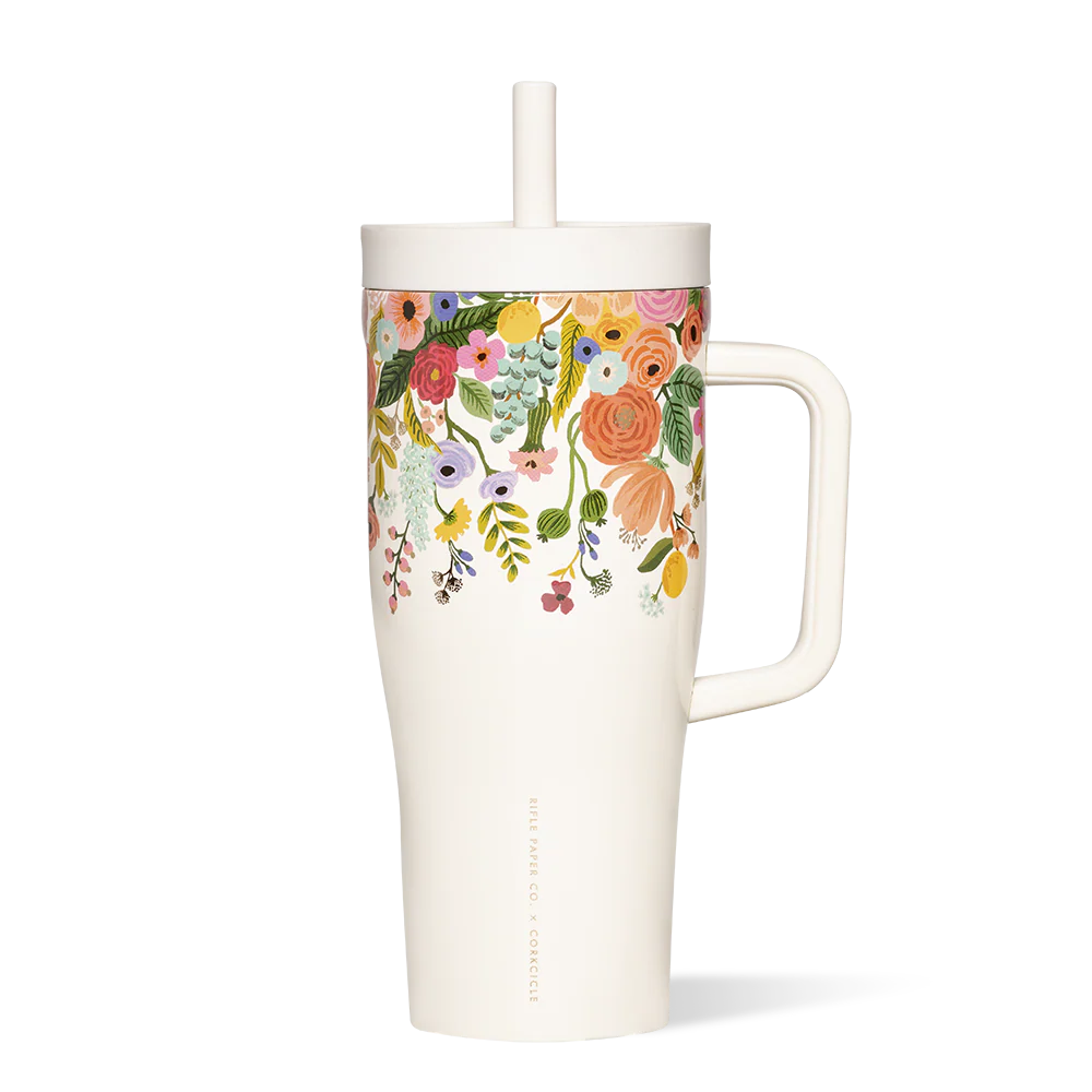 Floral-patterned mug with a handle and straw on a white background