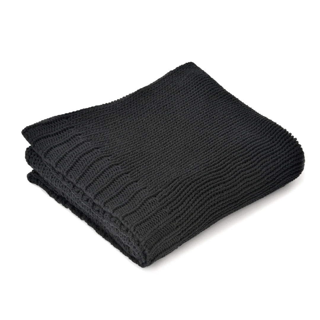 A folded black cotton throw blanket with ribbed texture on a white background.