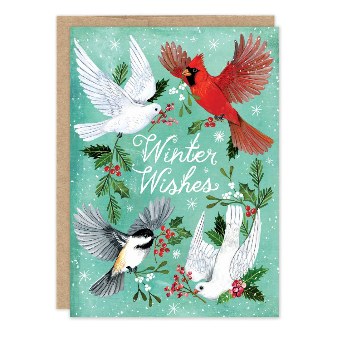 A winter-themed greeting card with a kraft envelope behind it. The card features four birds—a red cardinal, two white doves, and a chickadee—surrounded by holly leaves, berries, and snowflakes on a mint green background, with the words 'Winter Wishes' in white script.