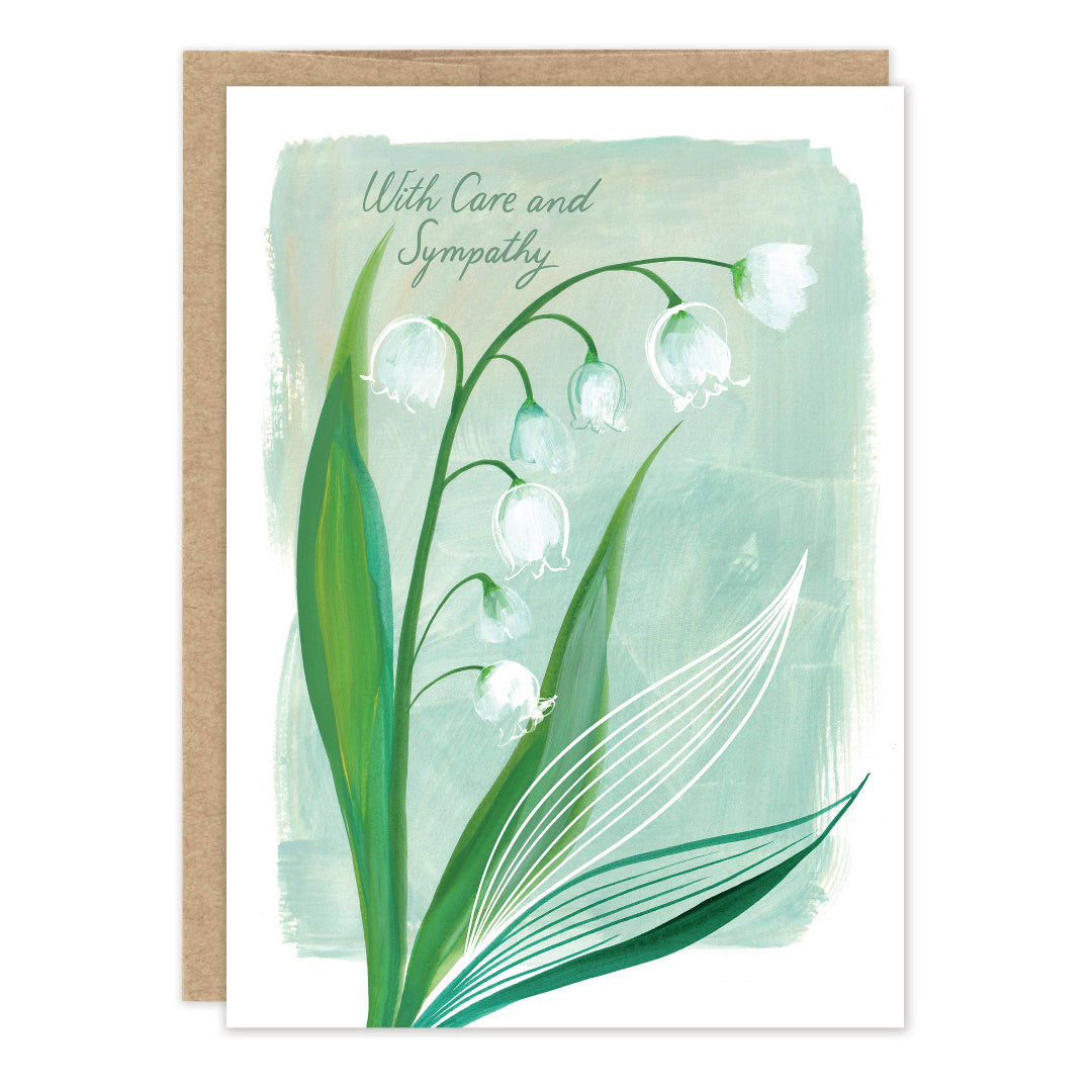 A greeting card with a kraft envelope, featuring a watercolor-style lily of the valley illustration and the words 'With Care and Sympathy' on a white card.
