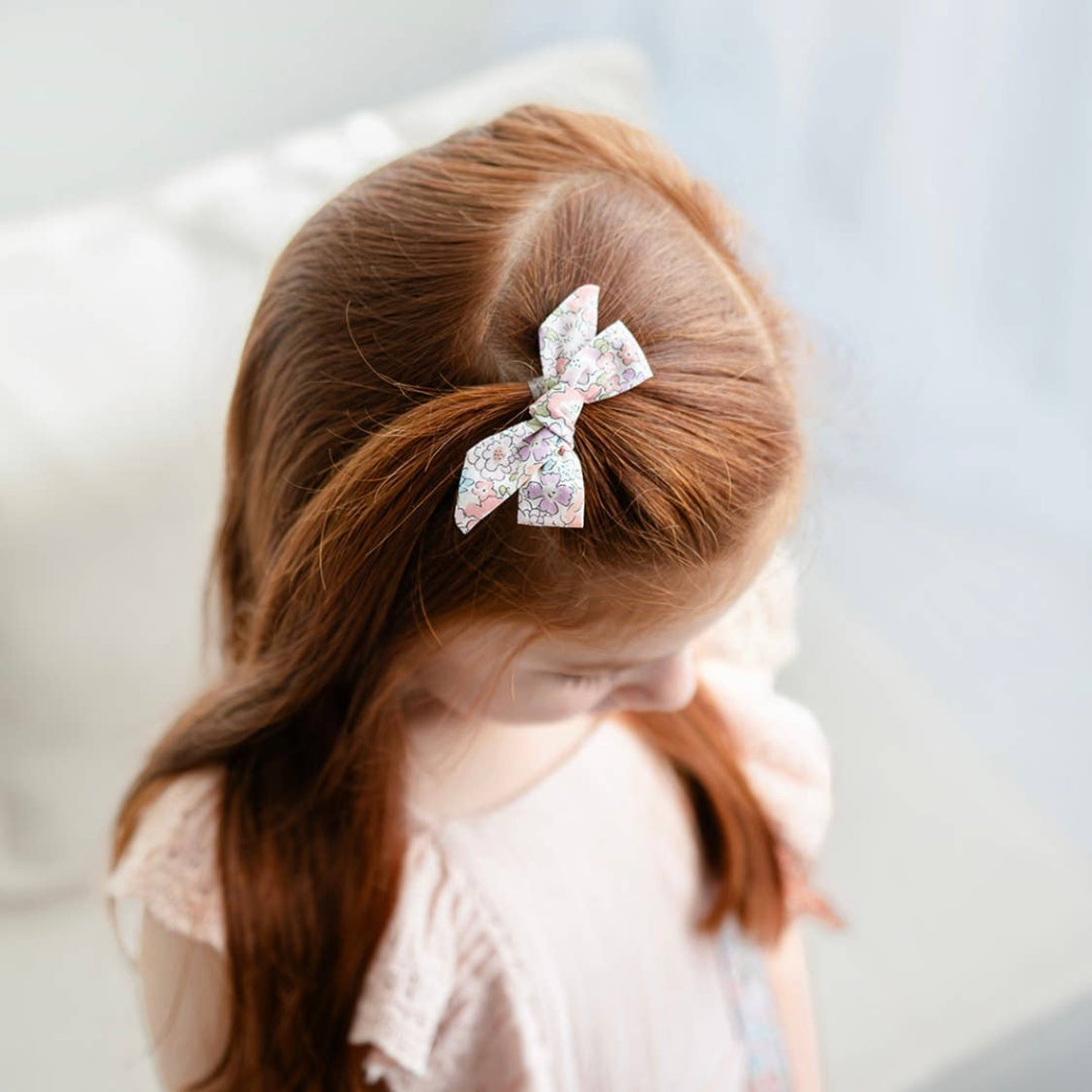 Child with a decorative bow against a light background