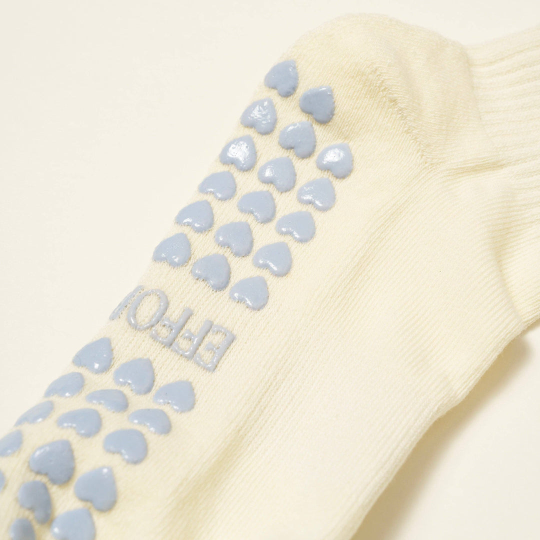 Beige sock with blue textured sole on a light background