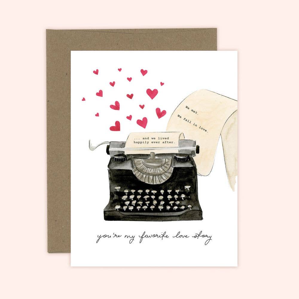 A greeting card with an illustration of a vintage typewriter with hearts and the phrase 'you're my favorite love story' written on a piece of paper.