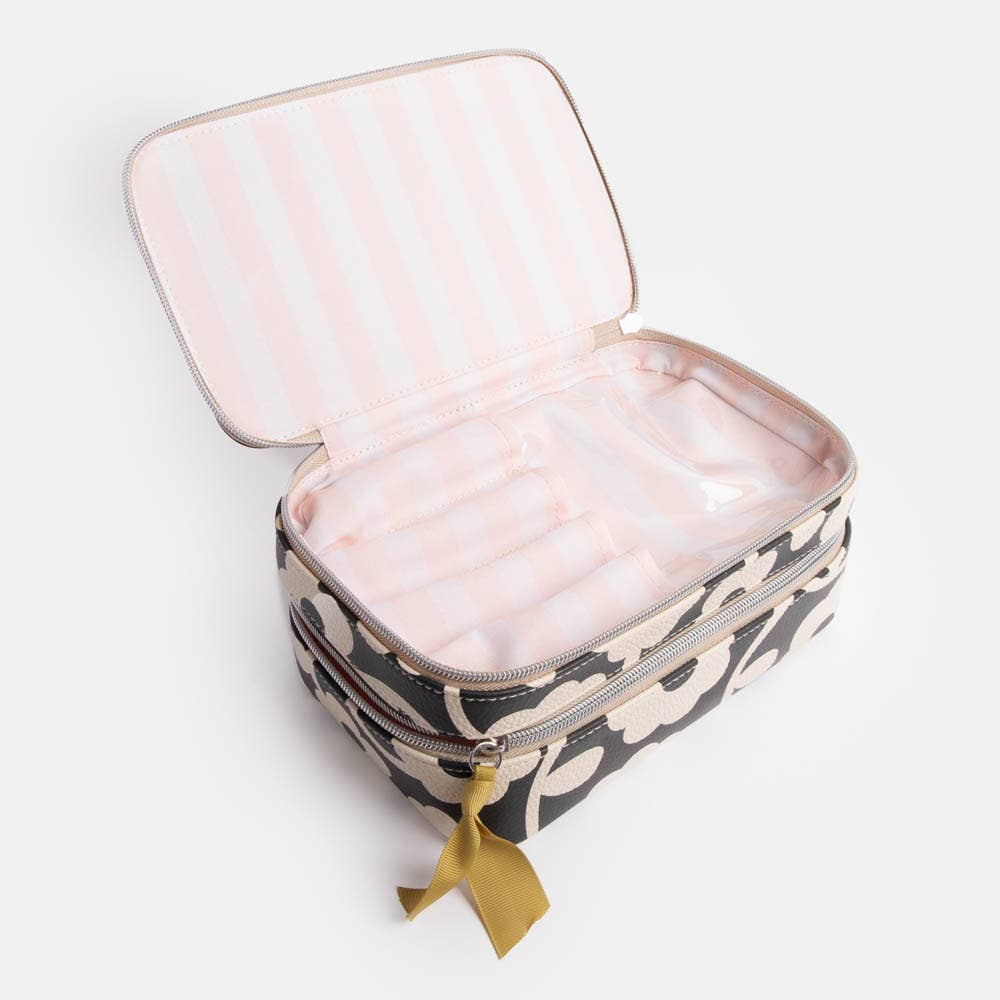 Cosmetic bag with pink interior and floral exterior on a light background