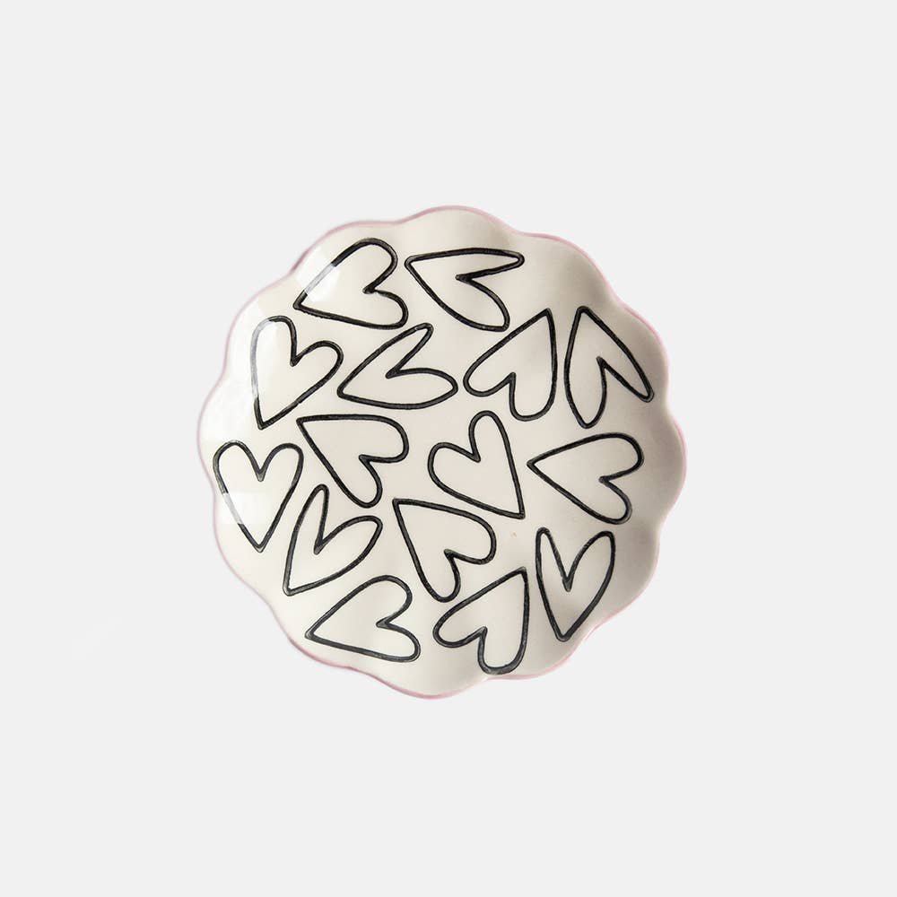 Decorative plate with black heart patterns on a white background