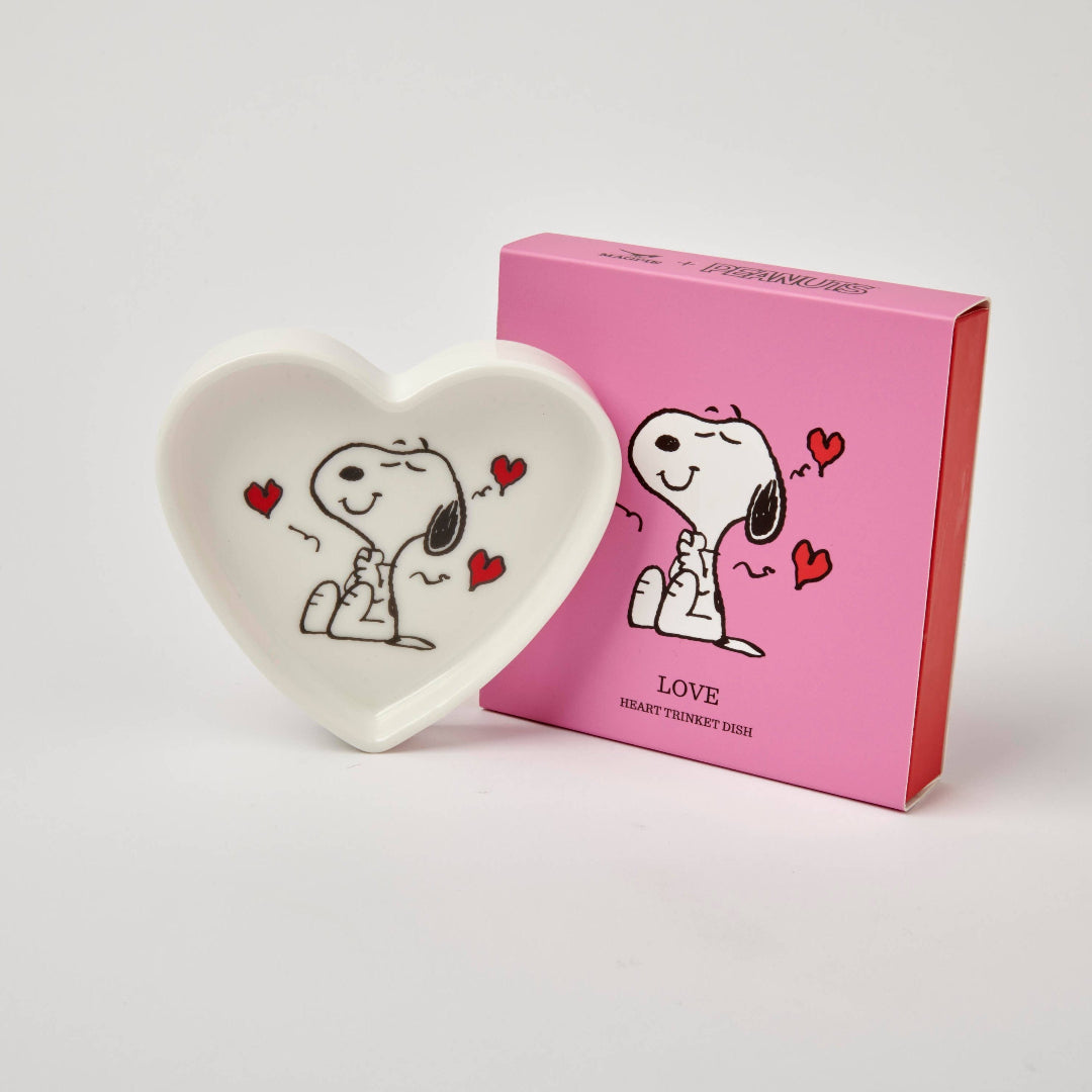 A heart-shaped ceramic trinket dish with a cartoon character Snoopy and hearts design, displayed next to a pink slide-out gift box.