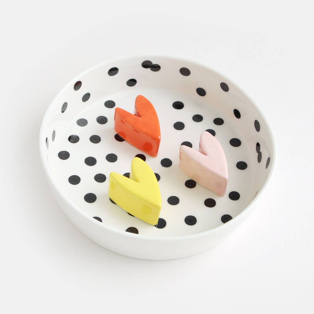 Polka dot bowl with colorful heart-shapes on a white background