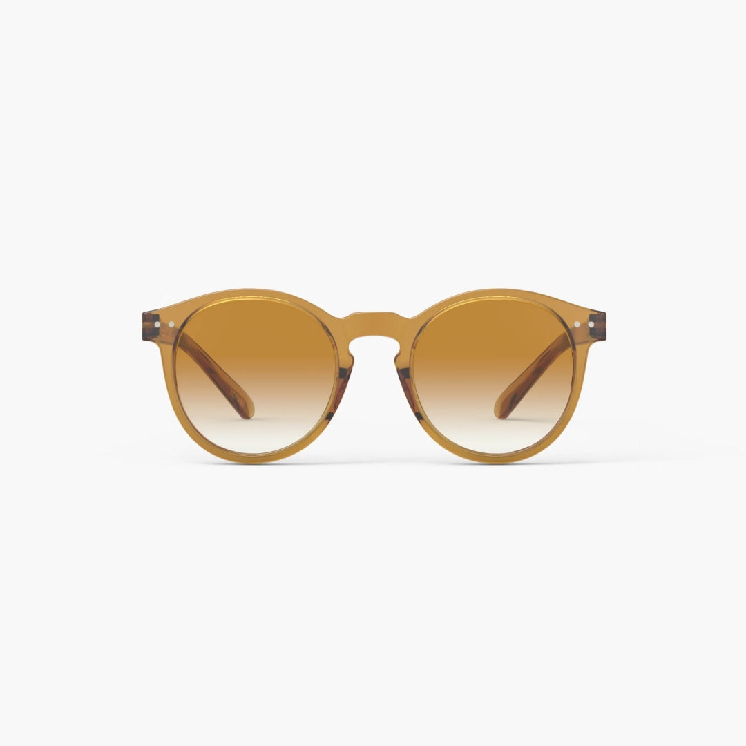Golden yellow sunglasses with gradient lenses on a white background