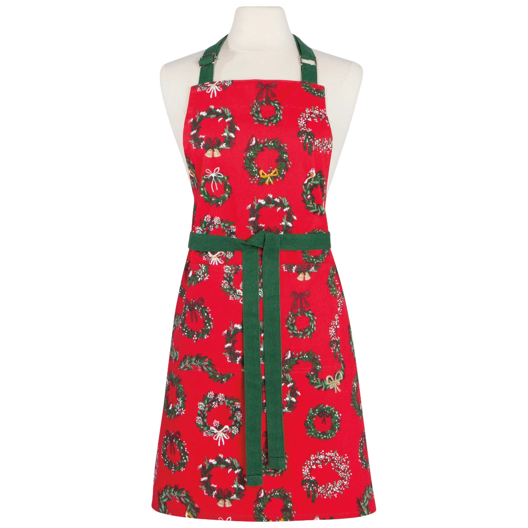 Red apron with green wreath pattern on a mannequin against a white background