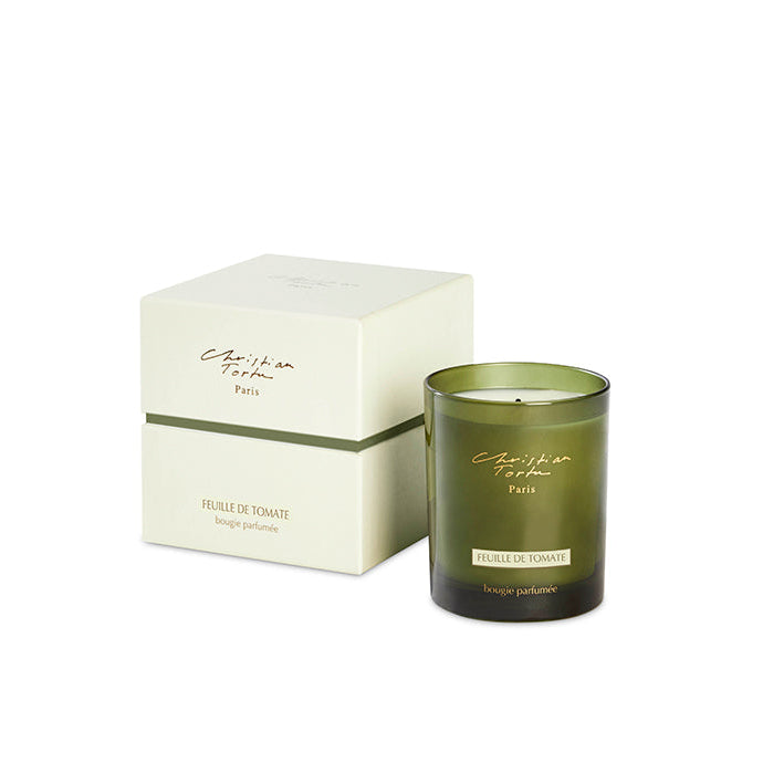 A green scented candle with a white box labeled 'Christian Tortu Paris' and 'Heart of the Garden'.