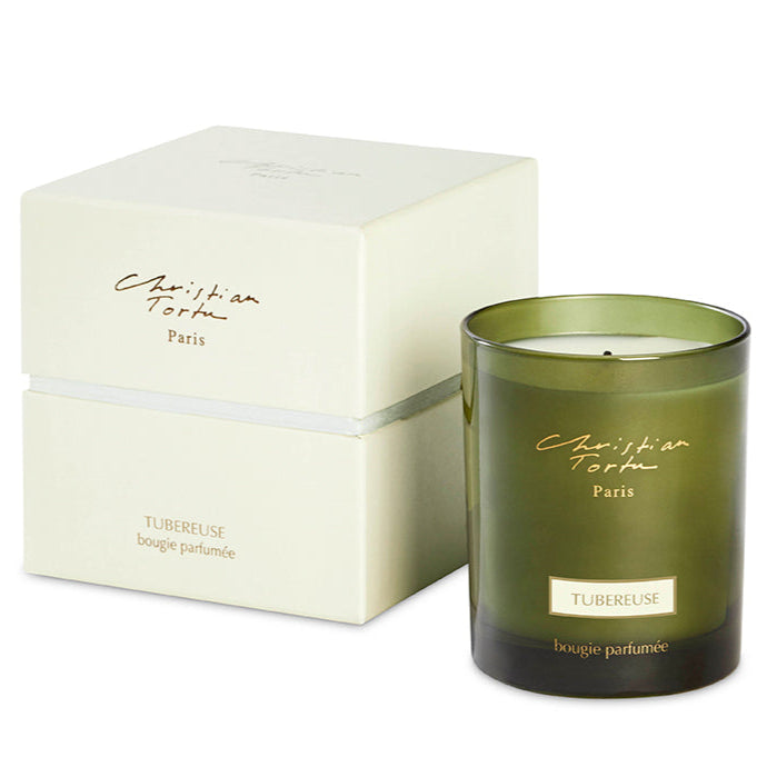 A tuberose scented candle in a green jar with a white lid, next to its white packaging box with the brand 'Christian Tortu' and the word 'Paris' printed on it.