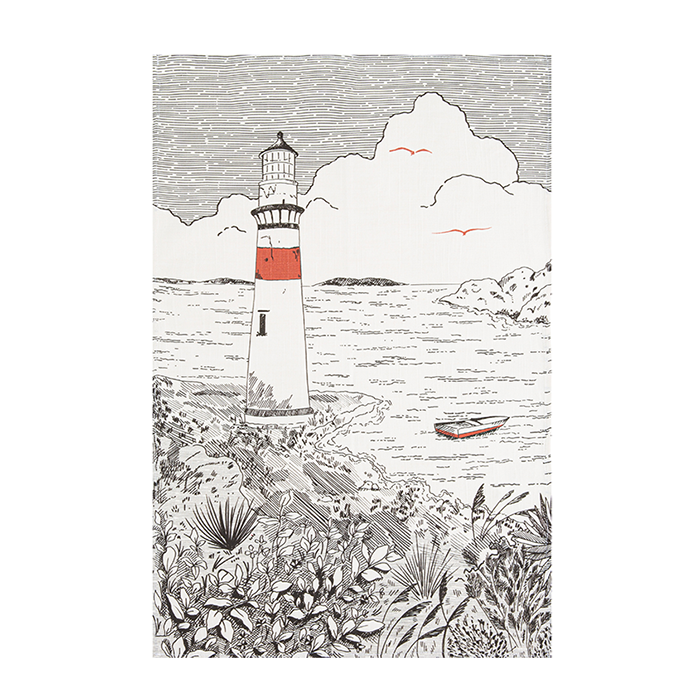 A black and white image of a tea towel with an illustration of a lighthouse, surrounded by foliage and a body of water in the background.