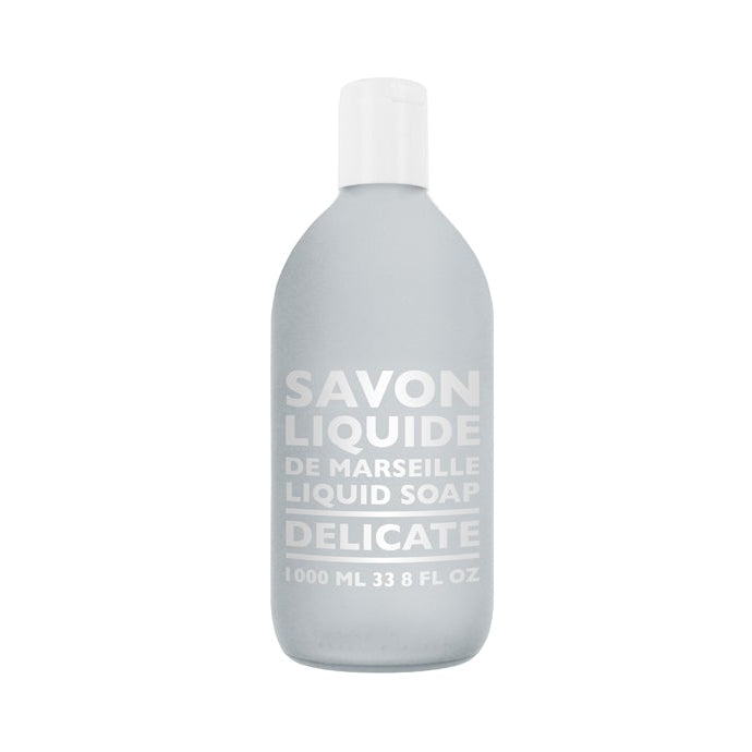 A gray plastic bottle labeled 'SAVON LIQUIDE DE MARSEILLE DELICATE' indicating it is a liquid soap refill.