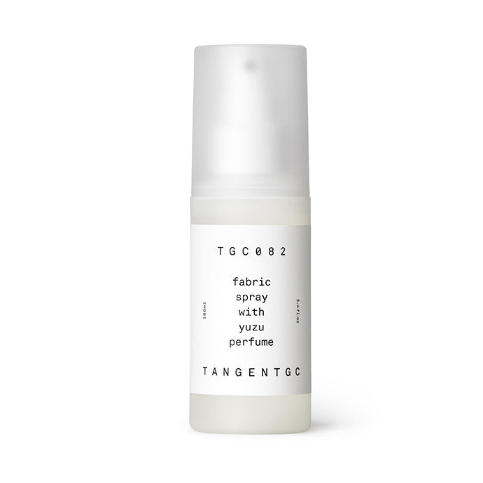 A white fabric spray bottle with a label reading 'Tangent GC Yuzu Fabric Spray with' and a small amount of liquid visible at the bottom.